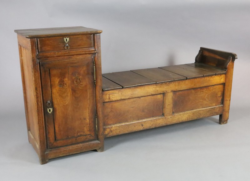 An early 19th century French oak box seat settle, with frieze drawer and cupboard flanking a box seat with central rising lid, W.6ft 2i